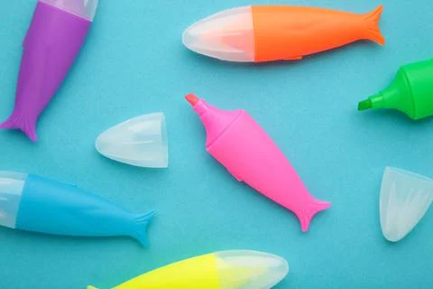 Colored markers for highlighting text on blue background. Stock Photos