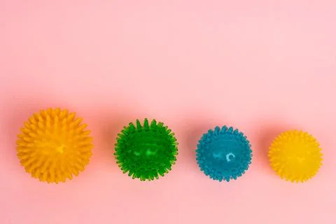 Colored massage needle balls of different sizes on a pink background, the Stock Photos
