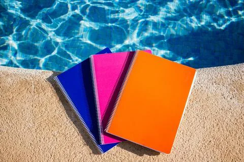 Colored notebooks next to a pool Stock Photos