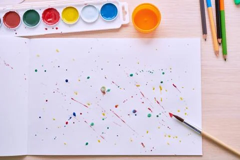 Colored paint on a white sheet and brush Stockfoto's