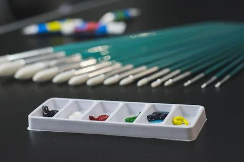 Colored paints with brushes Stock Photos