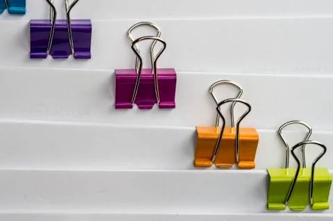 Colored paper binders on banch of paperwork Stock Photos
