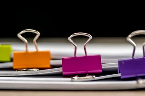 Colored paper binders on banch of paperwork Stock Photos