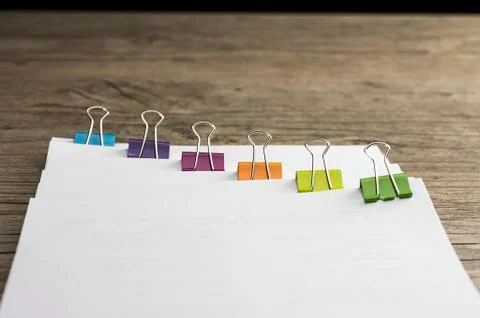 Colored paper binders on banch of paperwork Stock Photos