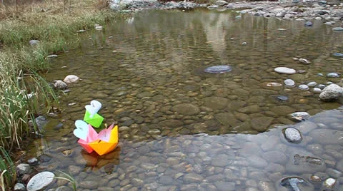 Colored paper boats floating on a small lake Stock Footage 22747631
