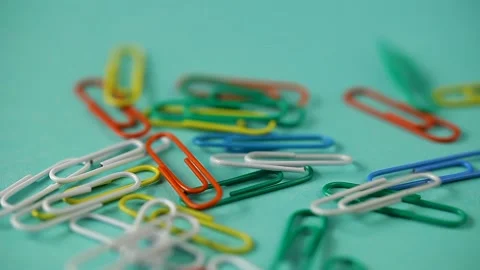 Colored paper clips fall on the blue  table. school supplies . Stock Footage 140198269