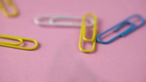 Colored paper clips fall on the pink table. school supplies. Stock Footage 140198275