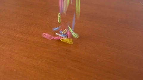 Colored Paper Clips Falls On The Table. Slow Motion Video. Stock Footage 150278969