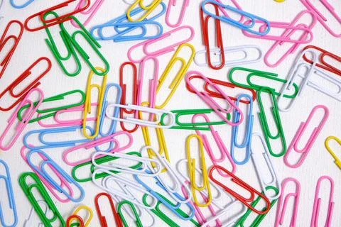 Colored paper clips on a white background. Stock Photos