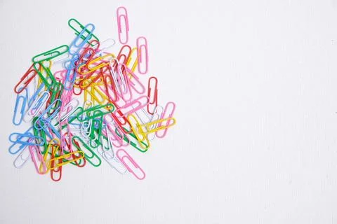 Colored paper clips on a white background. Stock Photos