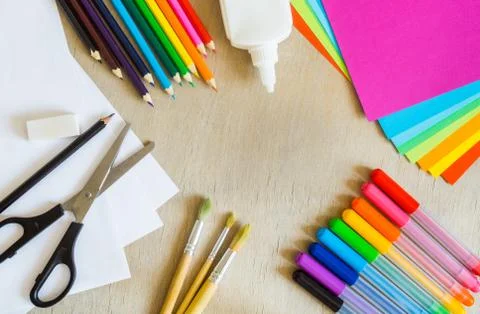 Colored paper, felt-tip pens, pencils, brushes on wooden background Stock Photos