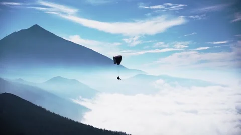 Colored paraglider flies against a background of blue sky and white clouds Stock Footage 170784801