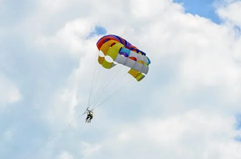 Colored parasail wing in the blue clouds sky, Parasailing also known as paras Foto stock