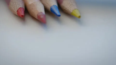 Colored pencil tips lying on a white piece of paper Stock Footage 274585440