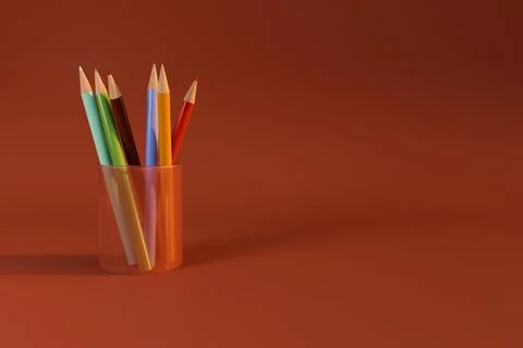 Colored pencil in transparent cup on red background Ilustración de archivo