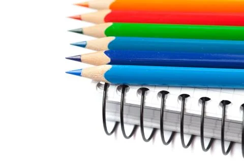 Colored pencils and a notebook isolated on white Stock-Fotos