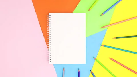 Colored pencils appear around open notebook on colorful theme. Stop motion Stock Footage 147490713