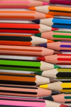 Colored pencils arranged in interlock pattern on white background 库存照片
