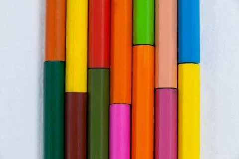 Colored pencils arranged in interlock pattern on white background Stock Photos