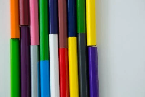 Colored pencils arranged in interlock pattern on white background Stock Photos