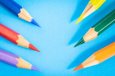 Colored pencils on a blue background. Stock Photos