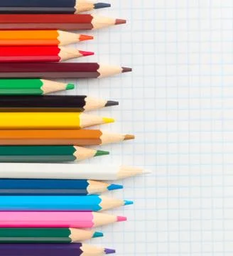 Colored pencils for drawing on a notebook in the cage Stock Photos