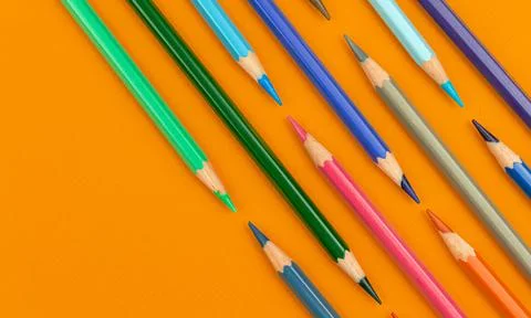 Colored pencils flat lay creative background, orange table top view photo Stock Photos