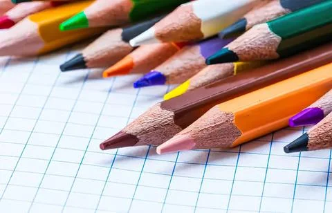 Colored pencils on graph paper in school or art setting Stock Photos