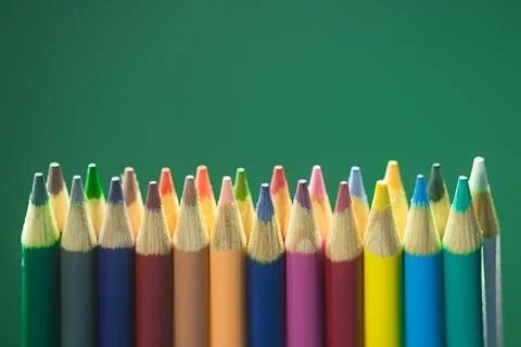 Colored Pencils on Green Backdrop Stock Photos