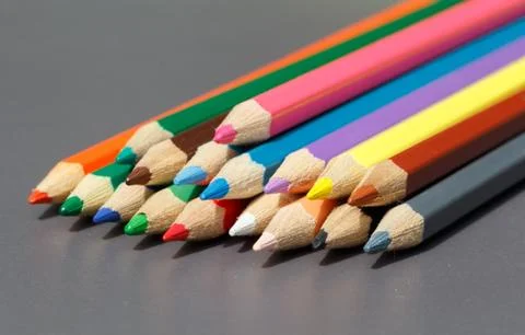 Colored pencils on grey background Stock Photos