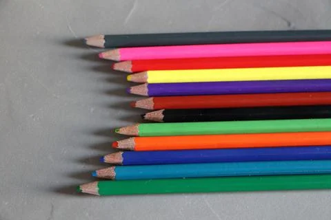 Colored pencils on grey background Stock Photos