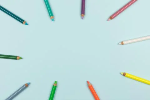 Colored pencils on a light blue background. Top view. Stock Photos