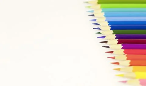Colored pencils lined up in a row on a white background with space for copy. Stock Photos