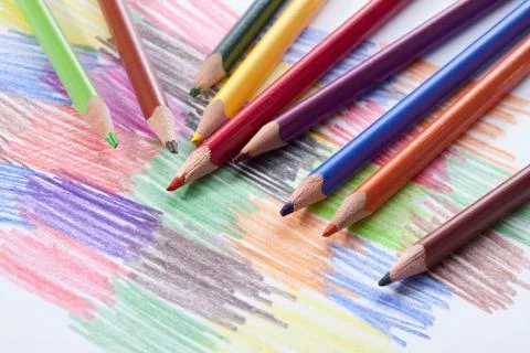 Colored pencils lying on a drawing with colored scribbles Foto stock