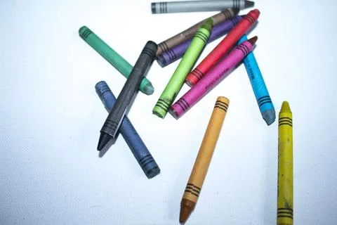 Colored pencils lying in irregular row on white background Stock Photos