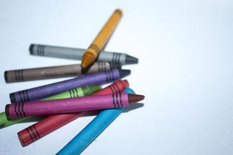 Colored pencils lying in irregular row on white background Stock Photos