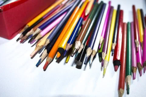 Colored pencils lying in irregular row on white background Stock Photos