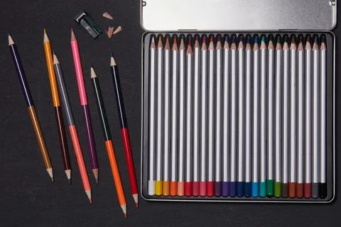Colored pencils in a metal box on a desk Stock Photos