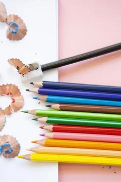 Colored pencils next to sharpener on blank page Stock Photos