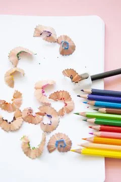 Colored pencils next to sharpener on blank page Stock Photos
