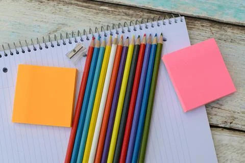 Colored pencils notebook and colored paper stickers school Stock Photos