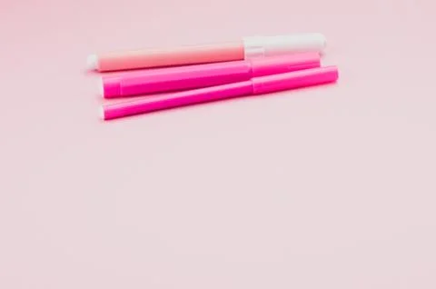 Colored pencils on a pink desk surface Stock Photos