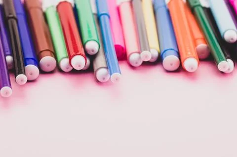 Colored pencils on a pink surface with copy space Stock Photos