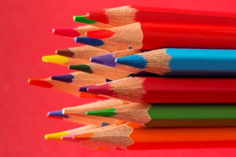 Colored pencils on red background Stock Photos