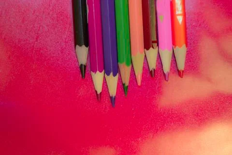 Colored pencils on red background Stock Photos