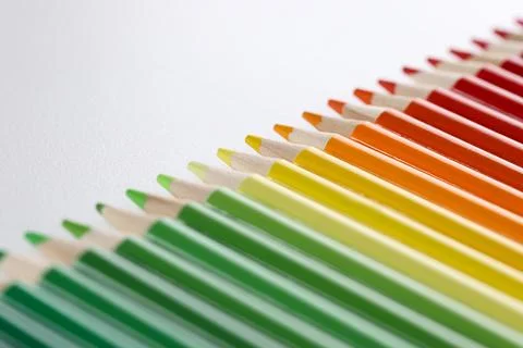 Colored pencils with sharp tips lie in a row, close-up Stock Photos