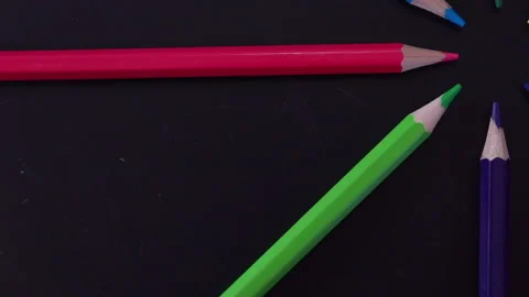 Colored pencils spinning on a black background Stock Footage 157941496