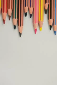 Colored pencils from the top margin, well sharpened, on white background, una Stock Photos