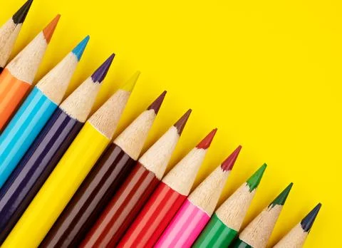 Colored pencils on a yellow background. Multi-colored pencils. Stock Photos