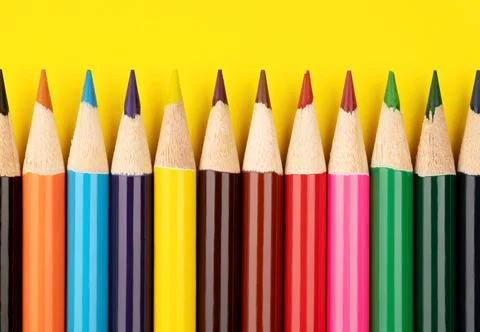 Colored pencils on a yellow background. Multi-colored pencils. Stock Photos